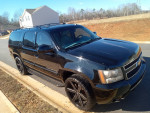2009 Chevrolet Suburban LTZ 4WD with new paint job and 24-inch wheels parked on a residential street.