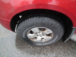 Close-up of a Nissan Pathfinder tire showing tread and alloy wheel, highlighting its rugged design and 4x4 capability.