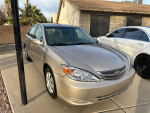 2004 Toyota Camry with champagne metallic exterior parked outside, showcasing low mileage and excellent condition.