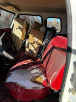 Interior of a 1978 Ford F250 showing worn red upholstery and boxes, highlighting the truck's work-in-progress state.