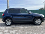 Side view of a 2011 Volkswagen Tiguan SEL 4Motion AWD in blue with alloy wheels and tinted windows