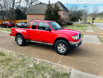 2003 Toyota Tacoma V6 pickup truck in red with 137,000 miles parked on a driveway.