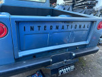 Back view of a blue 1965 International Harvester D100 truck showing logo and license plate details.