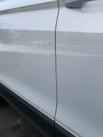 Close-up of the side panel of a 2018 Volkswagen Tiguan, showcasing its sleek design and finish.