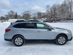 2016 Subaru Outback 2.5i AWD parked in snow, showcasing a clean exterior and all-wheel drive capabilities.