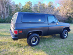 1987 GMC Jimmy Sierra Classic with fresh satin black paint parked in a grassy area, showcasing its rust-free condition.