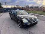 2002 Lexus LS 430 in black, featuring leather seats and sunroof, parked outdoors with a scenic backdrop.