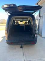 Interior view of 2006 Land Rover LR3 with spacious cargo area, black exterior and beige interior.