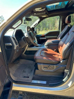 Interior of a 2018 Ford F-150 King Ranch showing brown leather seating and a panoramic sunroof.