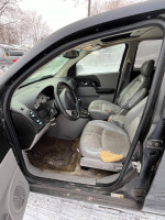 Interior view of a 2004 Saturn Vue with Honda engine, gray seating and worn upholstery.