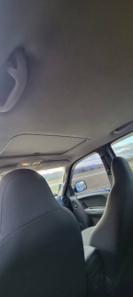 Interior view of a 2003 Jeep Liberty Sport with black seats and dashboard, highlighting second-hand vehicle's condition.