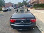 Rear view of a 2008 Audi A5 convertible parked on a residential street, showcasing its stylish design.