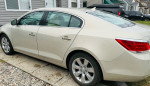Side view of a well-maintained 2011 Buick LaCrosse with no scratches, parked outside a home.