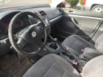 Interior view of a fire engine red 2007 VW Jetta with black cloth seats and manual transmission.