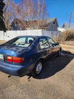 1995 Honda Civic DX parked, showcasing its clean exterior and original features, with minor paint fade.