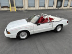 1992 Ford Mustang LX convertible in white with red interior, parked on asphalt, showcasing its sporty design.