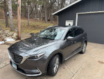 2019 Mazda CX-9 Grand Touring FWD parked in a driveway, showcasing its sleek design and features.