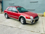 2003 Subaru Impreza Outback Sport AWD, low mileage, parked on pavement with clean background.