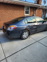 2009 Nissan Altima 2.5S with 56,000 miles, showing damage on the passenger side and rust on the body.