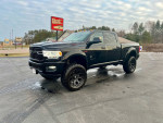 2021 Ram 2500 Crew Cab Big Horn Pickup with Black Widow package, lifted with large tires on a clean street.