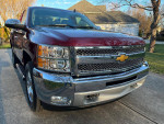 Front view of a 2013 Chevrolet Silverado 1500 in Deep Ruby color with chrome accents and new tires.