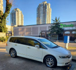 White 2007 Honda Odyssey parked near buildings, showcasing its clean exterior, perfect for families.