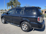 Black 2006 Honda Pilot EX-L SUV parked in daylight, showcasing its clean exterior and modern design.