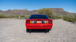 Red 1988 Chevrolet Camaro IROC parked in desert with mountains in background, featuring original design and modern upgrades.