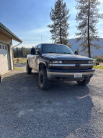 2000 Chevrolet Silverado 1500 with a 4-inch lift parked outdoors, showcasing its reliable design and decent condition.