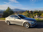 2008 Mercedes-Benz C300 luxury sedan parked on a scenic road, showcasing its sleek design and AMG wheels