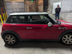 Side view of a red Mini Cooper in great condition with new tires and LED headlights