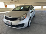 2012 Kia Rio with low mileage parked in a garage, featuring a clean design and good condition.