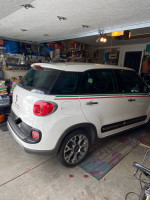 2014 Fiat 500L Trekking parked in garage, featuring Italian decals and stylish design.