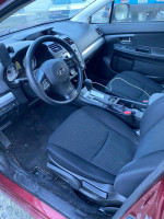 Interior view of a 2012 Subaru Impreza with black seats, steering wheel, and dashboard details.