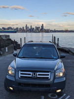 2006 Honda Pilot EX FWD parked near the water with a city skyline in the background