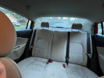 Interior view of 2013 Kia Rio showing khaki fabric seats and seat belts in the rear.