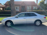 Silver 2005 Honda Accord LX parked on the street, showcasing its clean exterior and original mileage of 150,000.