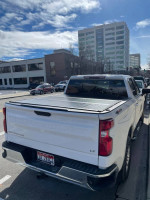 Rear view of a 2021 Chevrolet Silverado 1500 LT 4WD parked on the street, showcasing its pristine condition.