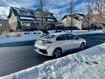 2019 Hyundai Ioniq Electric parked on a snowy street, showcasing its sleek design and low mileage.
