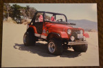 1974 Jeep CJ5 in sand, featuring a lifted suspension and off-road tires.