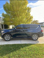 2020 INFINITI QX80 SUV in black parked outside, showcasing its sleek design and spacious body.
