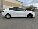 2015 Dodge Dart in white, side view showing clean lines and alloy wheels, parked in an outdoor lot.
