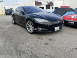 2014 Tesla Model S in black with premium interior and free supercharging, parked in a lot.