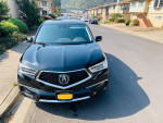 2018 Acura MDX Sport Hybrid in black parked on a street, showcasing its sleek design and luxurious features.
