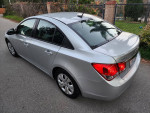 2014 Chevrolet Cruze LS in silver with clean exterior parked on the street, showcasing its modern design.