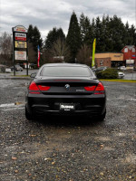 Rear view of a 2012 BMW 650i gran coupe with low mileage, showcasing its sleek design and luxury features.