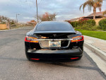 Rear view of a 2018 Tesla Model S P100D in black, showcasing sleek design and premium features.