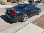 2001 Ford Saleen Mustang in black, showcasing unique rear design and wheels, parked on a suburban street.