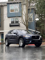 2018 Jaguar F-PACE in dark blue parked near a residential building, showcasing its sleek design and luxury features.
