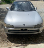 Front view of a 1991 Honda Beat convertible, not currently running, showing damage and new parts included.